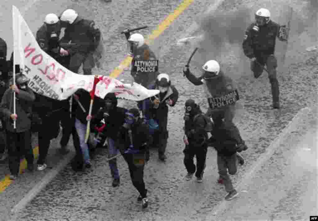 Riot police clash with protesters outside the Greek Parliament during a demonstration in central Athens, Wednesday, Dec. 15, 2010. Hundreds of protesters clashed with riot police across central Athens Wednesday, smashing cars and hurling gasoline bombs du