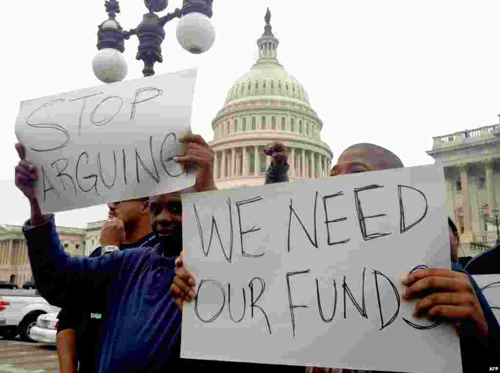 Protesters hold placards urging the U.S. Congress to end the federal government shutdown on Capitol Hill in Washington, D.C. 
