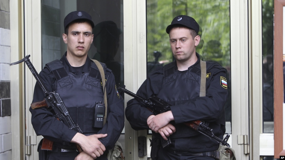 Russian police officers guard the entrance of the building where Russian opposition leader Alexei Navalny resides during a police search in Moscow, June 11, 2012. 