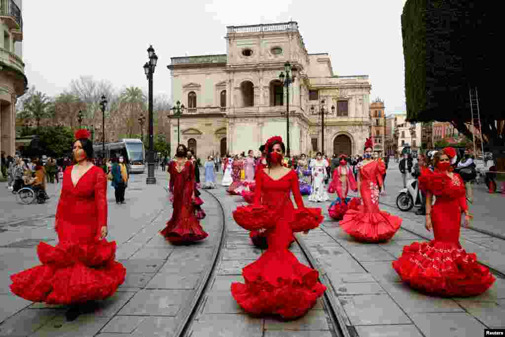 Women wearing flamenco dresses take part in a protest against the crisis in the flamenco fashion sector generated by the coronavirus pandemic, in Seville, Spain.