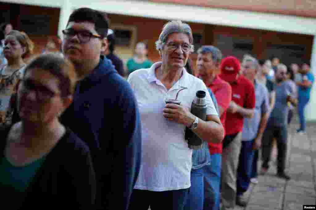 Un hombre sostiene una bebida mate mientras espera en una línea para votar en las elecciones generales de Paraguay en Asunción, Paraguay, el 30 de abril de 2023, cuando el país decide si abrazar el cambio o mantener al gobernante partido Colorado, en el poder desde hace más de siete décadas.