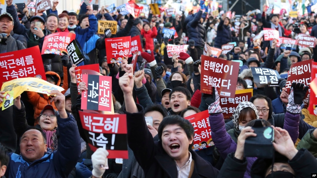 Para demonstran bersorak menyambut berita mengenai pemakzulan Presiden Korea Selatan Park Geun-hye, di depan Majelis Nasional di Seoul (9/12). (AP/Ahn Young-joon)