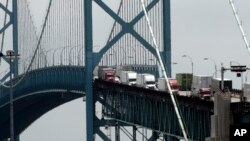 FILE - In this June 12, 2018, photo, trucks cross the Ambassador Bridge from Windsor, Ontario into Detroit. In nearly a quarter-century since NAFTA was approved, a complex chain of automotive parts makers has sprung up on both of the U.S.-Canada border. 