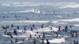 Surfers ride waves at Shonan beach in Fujisawa city, west of Tokyo, Japan. Heat wave continues through out Japan as temperature sores to 35 degrees Celsius (95 degrees Fahrenheit) in the Tokyo metropolitan area, according to the Meteorological bureau.
