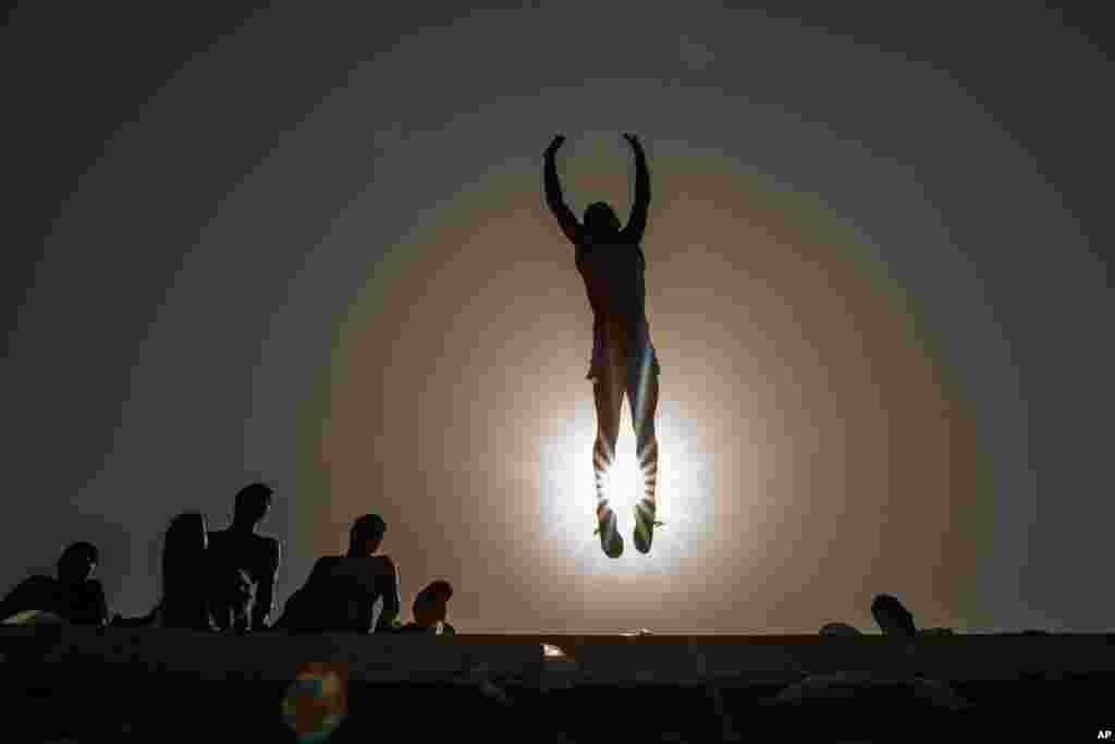 A youth jumps into the Mediterranean Sea off the corniche during a lockdown to curb the spread of coronavirus in Saida, Lebanon, May 2, 2021.