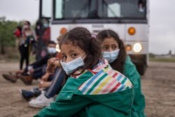 Chanel, 7, and her sister Adriana, 10, both unaccompanied minors traveling alone from Honduras, wait with other asylum-seeking children in La Joya, Texas, May 6, 2021.