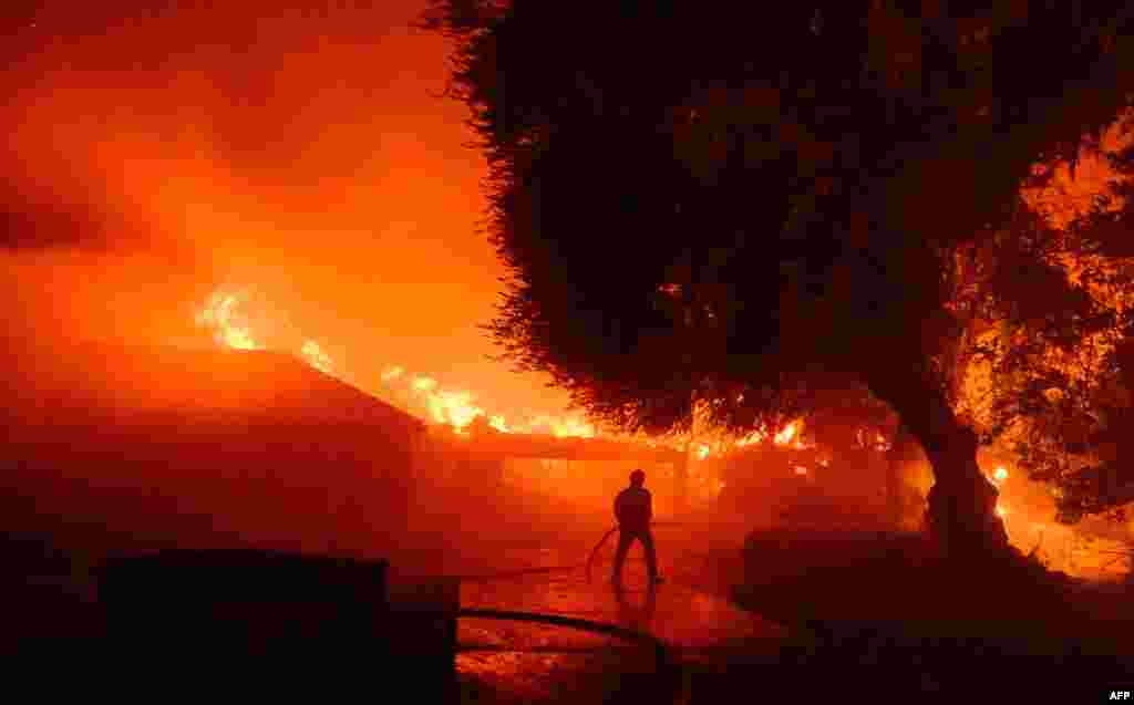 Un bombero trabaja en la zona afectada por los incendios mientras docenas de casas continúan ardiendo en Eaton, en el área de Altadena del condado de Los Ángeles, California, el 8 de enero de 2025.