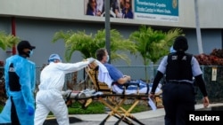 Emergency Medical Technicians (EMT) arrive with a correctional patient at North Shore Medical Center where the coronavirus disease (COVID-19) patients are treated, in Miami, Florida, July 14, 2020.