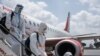 Passengers wearing full personal protective gears get off a plane at Jomo Kenyatta International Airport in Nairobi, Kenya, on January 19, 2021.