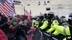 FILE - Rioters loyal to President Donald Trump clash with police at the U.S. Capitol on Jan. 6, 2021, in Washington.