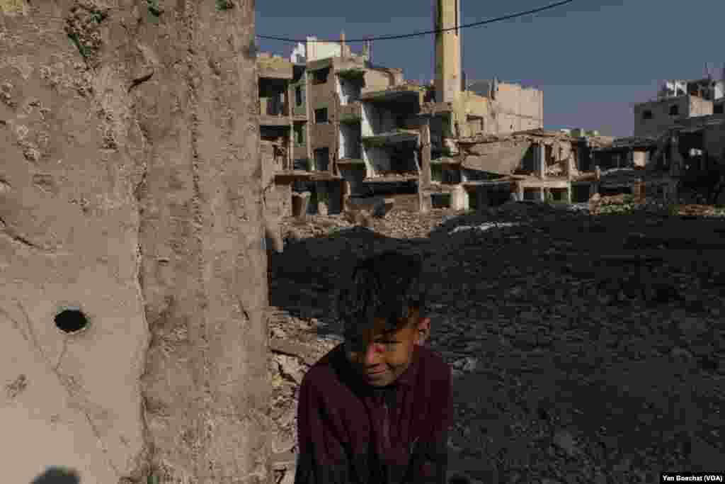 A young Palestinian boy plays among the ruins of the former Palestinian refugee camp of Yarmuk, destroyed by regime forces during the Syrian civil war.