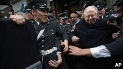 FILE - The Rev. Fernando Karadima, right, is escorted from court after testifying in a lawsuit brought by three people alleging a sex abuse cover-up by the Archdiocese of Santiago, Nov. 11, 2015. 