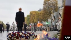 French President Emmanuel Macron stands in front of the flame to the Unknown Soldier at the Arc de Triomphe in Paris on Nov. 11, 2019 as part of commemorations marking the 101st anniversary of the 11 November 1918 armistice.