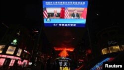A screen displays a CCTV state media news broadcast showing Chinese President Xi Jinping and U.S. President Joe Biden during a virtual summit, in Beijing, China, Nov. 16, 2021.