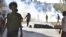 FILE - Protesters against the military coup in Sudan walk past fumes of tear gas fired by security forces during a demonstration in 'Street 60' in the east of capital Khartoum on Nov. 13, 2021.