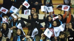 Iranian women wave flags of reformists for the parliamentary elections in a campaign rally in Tehran, Iran, Feb. 18, 2016. 