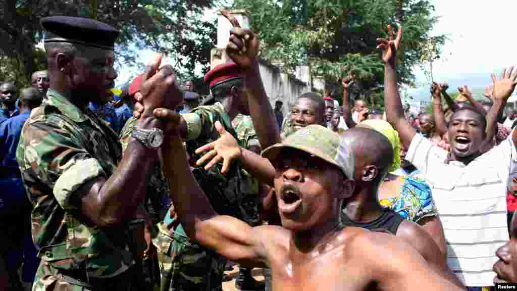 La foule salue des soldats alors qu&#39;elle célèbre après l&rsquo;annonce de la destitution du président Pierre Nkurunziza par un haut gradé de l&rsquo;armée à Bujumbura, au Burundi le 13 mai 2015.