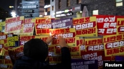 10일 한국 여의도에 위치한 집권여당 국민의힘 당사에서 시민들이 윤석열 한국 대통령에 대한 탄핵 시위를 벌이고 있다.