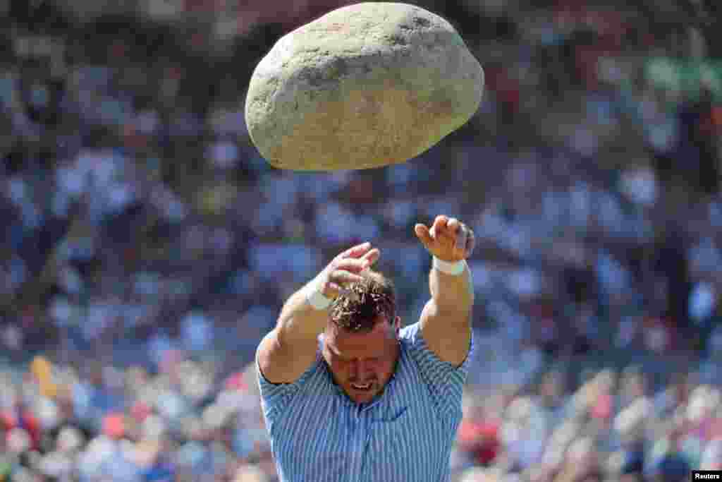 Martin Jakober throws the 83.5kg Unspunnen stone during the ESAF-Federal Alpine Wrestling Festival in Zug, Switzerland.