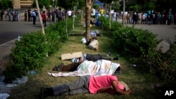 Para pendukung mantan presiden Mohamed Morsi tidur di pinggir jalan dalam protes di luar markas tentara Republican Guard di Nasr City, Kairo (9/7). (AP/Khalil Hamra)