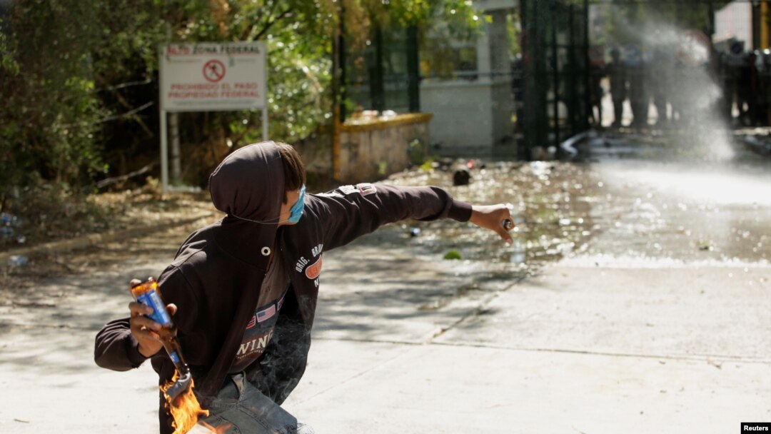 Seorang demonstran melempar bom molotov ke anggota Pengawal Nasional Meksiko selama protes terhadap keputusan pemerintah Meksiko untuk mengalihkan air dari bendungan La Boquilla ke AS. (Foto: Reuters)
