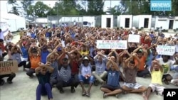 FILE - In this file photo made from Australia Broadcasting Corporation video taken shows asylum seekers protesting the possible closure of their detention center on Manus Island, Papua New Guinea, Oct. 31, 2017.