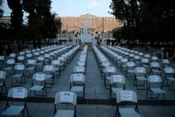 Empty chairs with various slogans from the union of bars and restaurants owners are placed at Athens' main Syntagma square May 6, 2020.