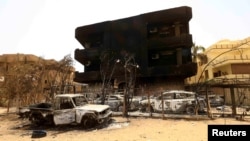 Damaged cars and buildings are seen at the central market in Khartoum North