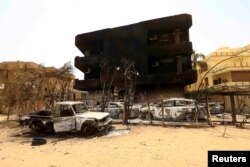 Mobil dan bangunan yang rusak akibat bentrokan antara paramiliter dan tentara di Khartoum Utara, Sudan, 27 April 2023. (Foto: REUTERS/ Mohamed Nureldin Abdallah)