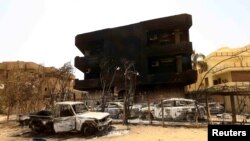 FILE: Damaged cars and buildings are seen at the central market during clashes between the paramilitary Rapid Support Forces and the army in Khartoum North, Sudan April 27, 2023. 