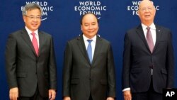 Vietnamese Prime Minister Nguyen Xuan Phuc, center, Chinese Vice Premier Hu Chunhua, left, and Klaus Schwab, executive chair of the World Economic Forum, pose prior to the World Economic Forum on ASEAN Wednesday, Sept. 12, 2018 .