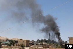 FILE - A plume of smoke rises amid ongoing fighting between Afghan security forces and Taliban insurgeents in the western city of Qala-e-Naw, the capital of Afghanistan's Badghis province, July 7, 2021.
