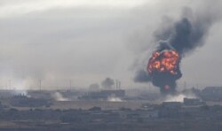 An explosion is seen over the Syrian town of Ras al-Ain, as seen from the Turkish border town of Ceylanpinar, Sanliurfa province, Turkey, Oct. 12, 2019.