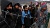 Migranti posmatraju bosanske vojnike koji podižu štore u kampu Lipa, nedaleko od Bihaća, u Bosni i Hercegovini, 1. januara 2021.