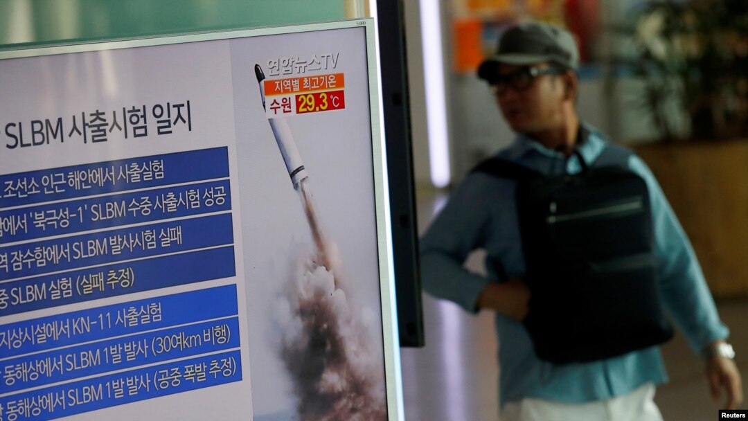 Seorang penumpang kereta api melewati layar televisi di stasiun kereta api Seoul, yang menayangkan berita terkait peluncuran misil dari kapal selam Korea Utara, 24 Agustus 2016 (Foto: REUTERS/Kim Hong-Ji)