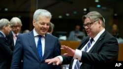 FILE - Belgian Foreign Minister Didier Reynders, left, speaks with Finnish Foreign Minister Timo Juhani Soini during a meeting of EU foreign ministers at the EU Council building in Brussels on Monday, Nov. 14