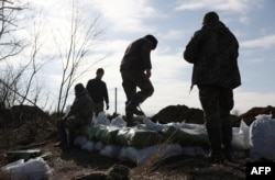 Ukrainian servicemen pile bags of earth to build a fortification not far from town of Avdiivka in the Donetsk region, amid the Russian invasion of Ukraine, Feb. 17, 2024.