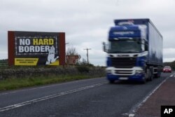 A truck races past a sign against the reestablishment of a hard border between Northern Ireland and the Republic of Ireland, Oct. 1, 2019.