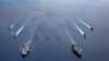 In this photo provided by U.S. Navy, the USS Ronald Reagan (CVN 76) and USS Nimitz (CVN 68) Carrier Strike Groups steam in formation, in the South China Sea, July 6, 2020. 