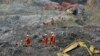 In this photo taken Saturday, Mar. 30, 2013, rescuers search through rocks and debris at a gold mine after a mudslide in Gyama village, in Maizhokunggar County of Lhasa, Tibet.