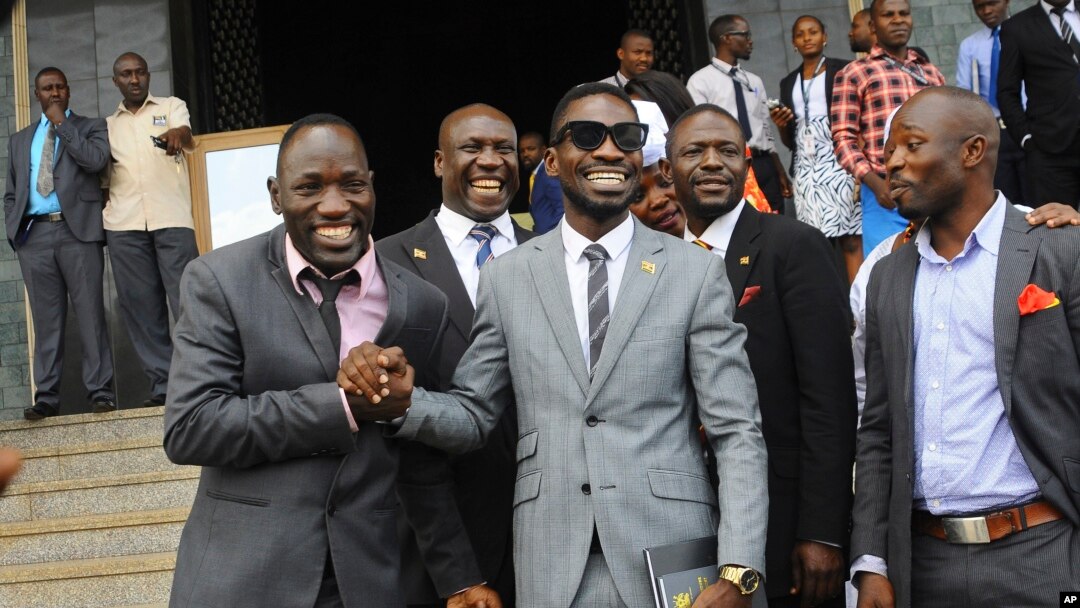 FILE - Ugandan pop star Kyagulanyi Ssentamu, better known as Bobi Wine, center, leaves shortly after being sworn in as a member of parliament in Kampala, Uganda, July 11, 2017.