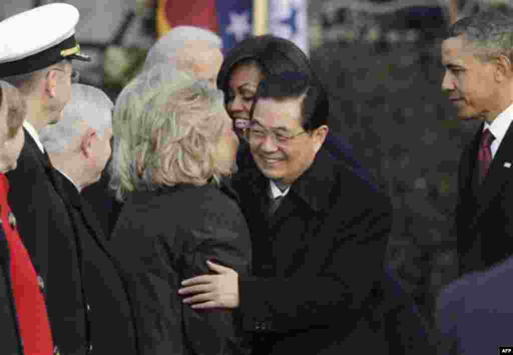 China's President Hu Jintao is embraced by Secretary of State Hillary Rodham Clinton as President Barack Obama and first lady Michelle Obama host a state arrival ceremony on the South Lawn of the White House in Washington, Wednesday, Jan. 19, 2011. (AP Ph