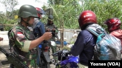 Prajurit Yonif 303 Kostrad memeriksa identitas warga yang keluar masuk ke desa Torire, Lore Tengah (Foto: VOA/ Yoanes)