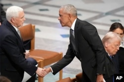 Mantan Presiden Barack Obama berjabat tangan dengan mantan Wakil Presiden Mike Pence sebelum pemakaman kenegaraan untuk mantan Presiden Jimmy Carter di Katedral Nasional Washington di Washington, Kamis, 9 Januari 2025. (Jacquelyn Martin/AP)