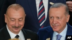 Ilham Aliyev, Azerbaijan president, and Turkey President Recep Tayyip Erdogan, right, pose for a group photo at the COP29 U.N. Climate Summit, Nov. 12, 2024, in Baku, Azerbaijan.