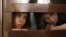 Nadezhda Tolokonnikova (L) and Maria Alyokhina, members of female punk band "Pussy Riot", look out from the defendent's cell in a courtroom in Moscow July 30, 2012. 