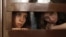 FILE - Nadezhda Tolokonnikova (L) and Maria Alyokhina, members of female punk band "Pussy Riot", look out from the defendent's cell in a courtroom in Moscow July 30, 2012. 
