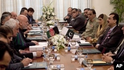 Afghan President Hamid Karzai, fourth from left, talks with Pakistan's Prime Minister Yousaf Raza Gilani, right, at the prime minister's house in Islamabad, Pakistan, February 16, 2012.