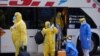 Los tripulantes del crucero australiano Greg Mortimer, con trajes protectores para evitar la contaminación con el coronavirus, llegan a un hotel en Montevideo, Uruguay, el 12 de mayo de 2020.