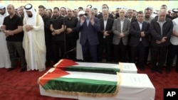 Tangkapan layari video ini menunjukkan pejabat senior Hamas Khalil al-Hayya, tengah, berdoa di depan peti mati pemimpin Hamas Ismail Haniyeh yang terbunuh dan pengawalnya saat salat jenazah di Doha, Qatar, pada Jumat 2024. (Qatar TV via AP )